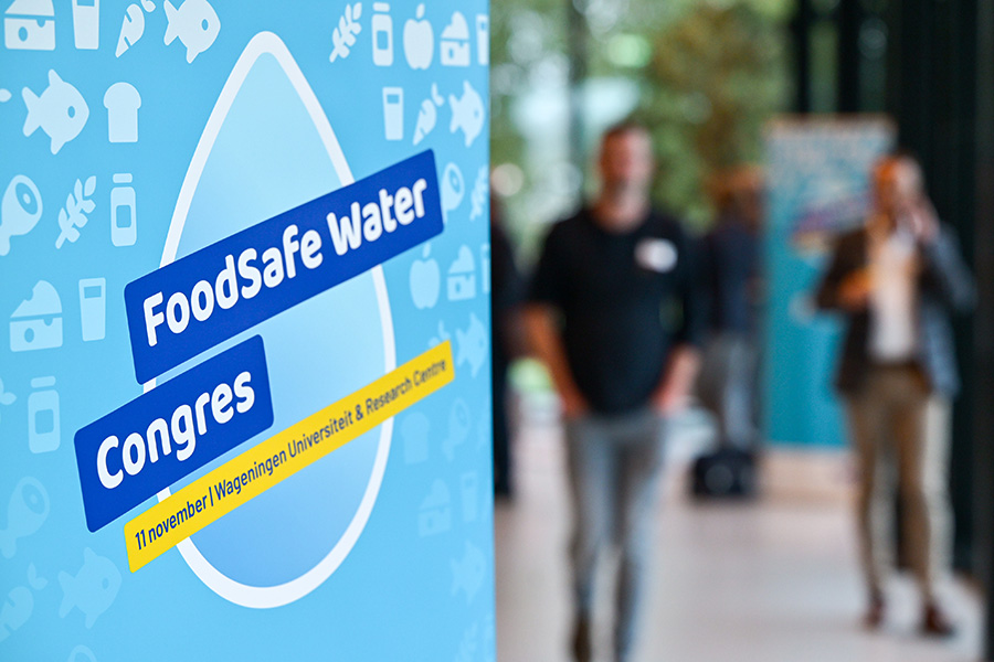 Blauwe banner met tekst FoodSafe Water Congres en op de achtergrond mensen.